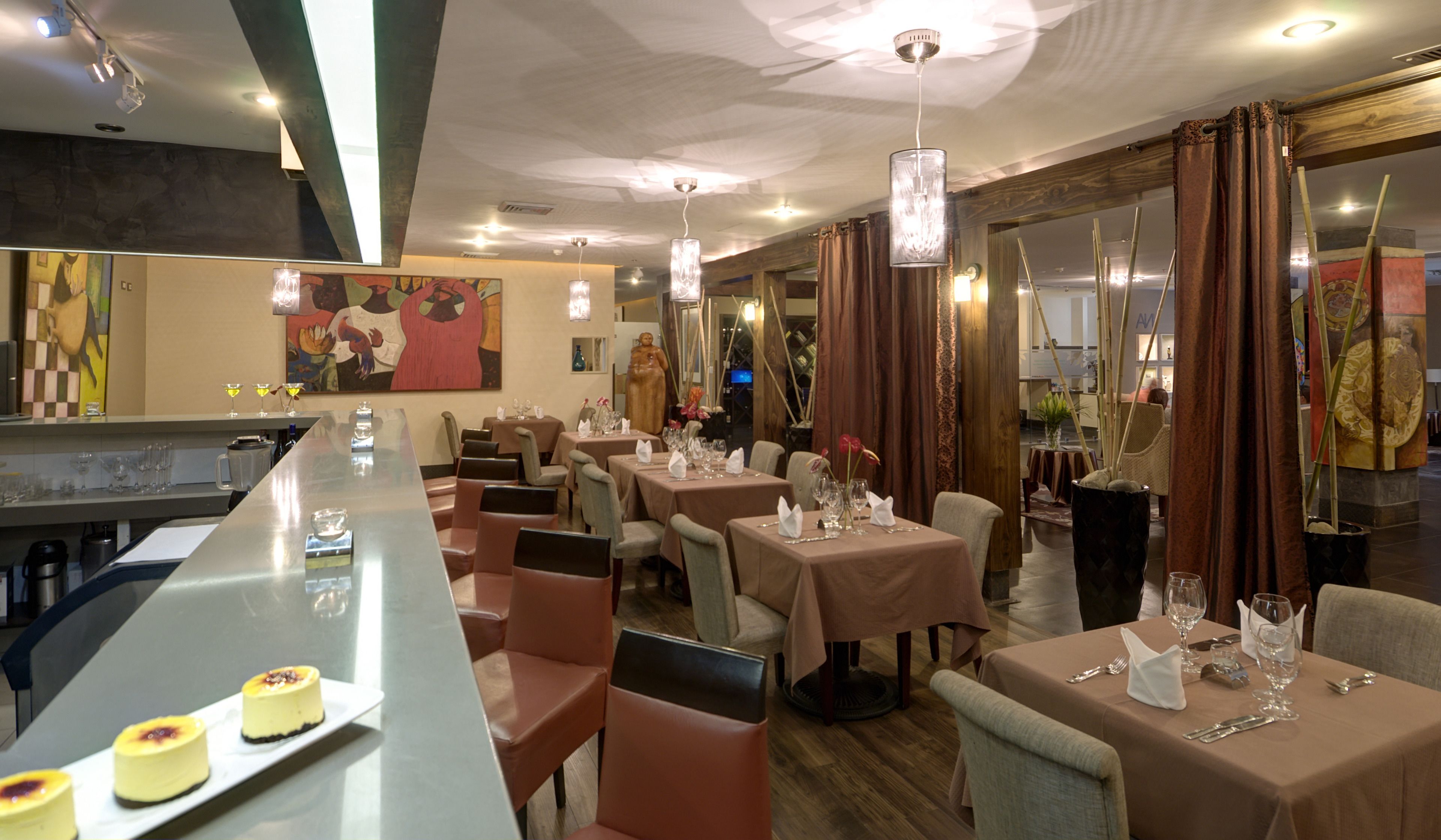 A restaurant with multiple tables, chairs, and a bar area.