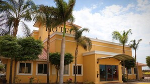 En gul bygning med et skilt der siger "HOTEL" og en overdækket indgang.