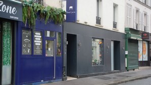 A storefront with a blue awning and a sign for 'Portal Latino'. - Enjoy Hostel (Paris)