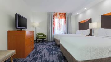 Une chambre d’hôtel avec un lit, une télévision, un bureau et une chaise.