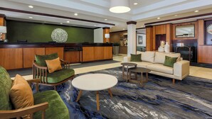 A lobby with a reception desk, seating area, and a fireplace. - Fairfield Inn & Suites Mahwah (Mahwah)