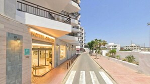 Un hotel con una fachada moderna, una entrada visible y un paso de peatones bien definido.