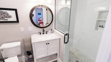 A bathroom with a toilet, sink, and shower.