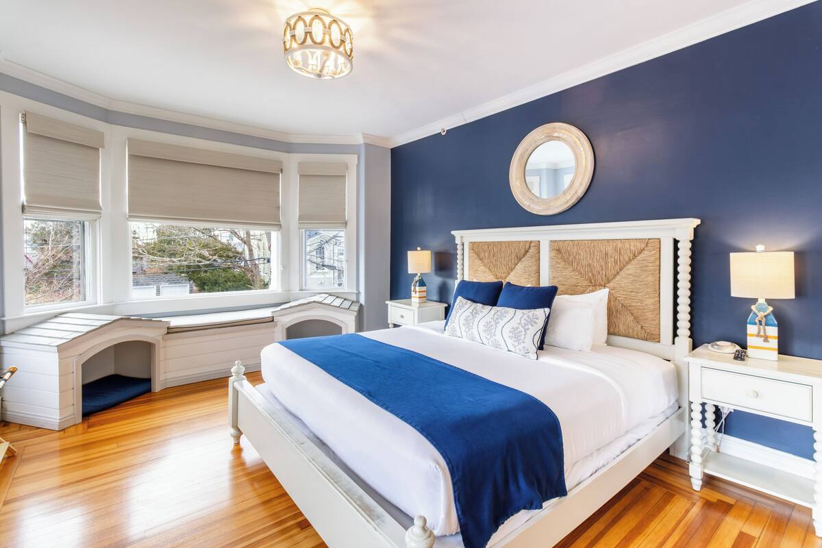 A bedroom with a large bed, a window seat, and a view of the outside.