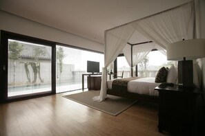 Quarto moderno com uma cama grande, uma televisão e vista para o exterior.