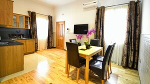 A compact living space with a kitchen, dining area, and a TV.