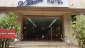 The exterior of Ascot Hotel with a sign indicating hotel parking. - Ascot Hotel (Mumbai)