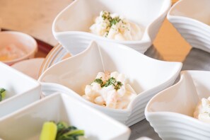 A series of white, star-shaped bowls containing a creamy dish, possibly seafood, garnished with herbs.