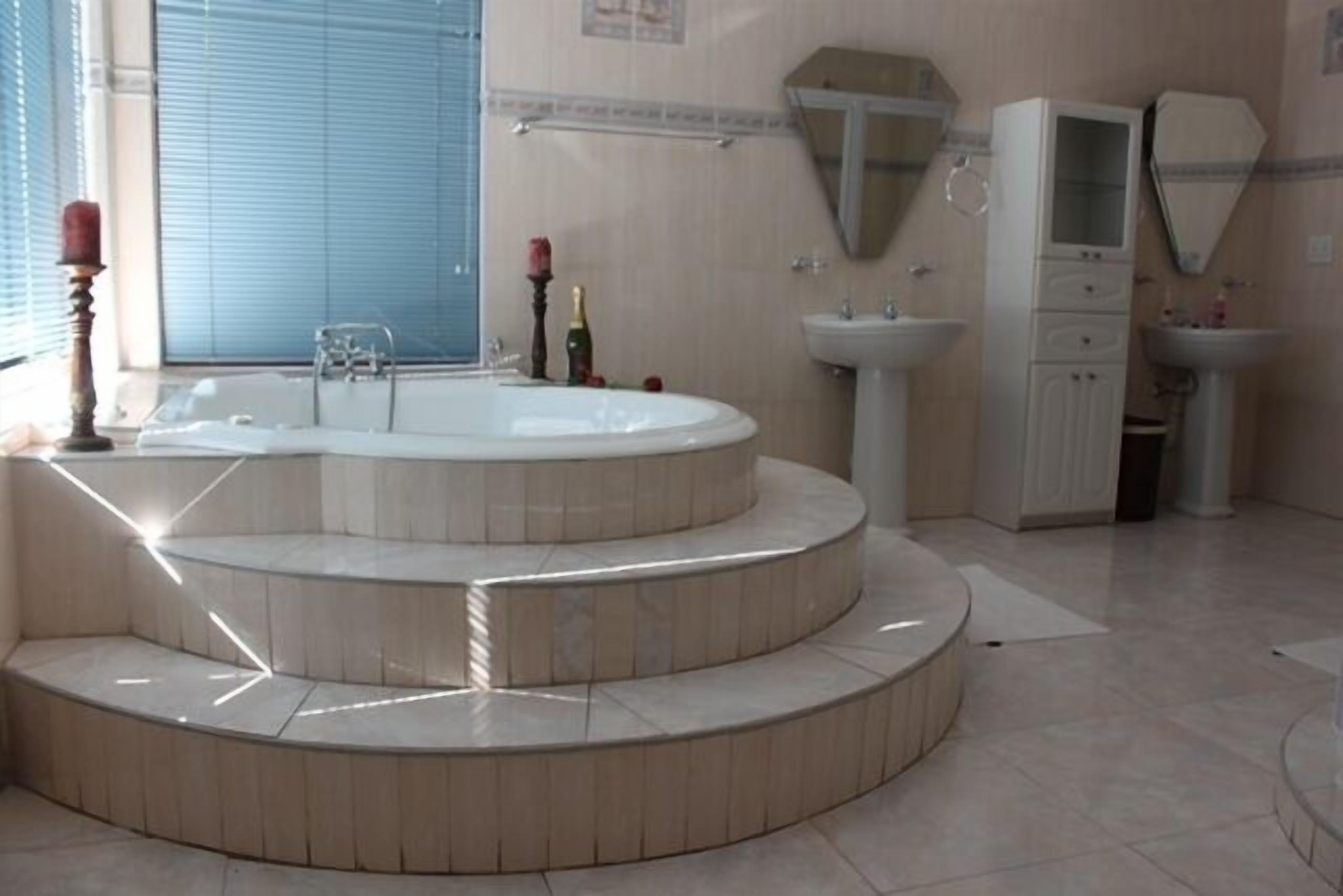 A bathroom with a freestanding bathtub, a sink, a mirror, and a cabinet.