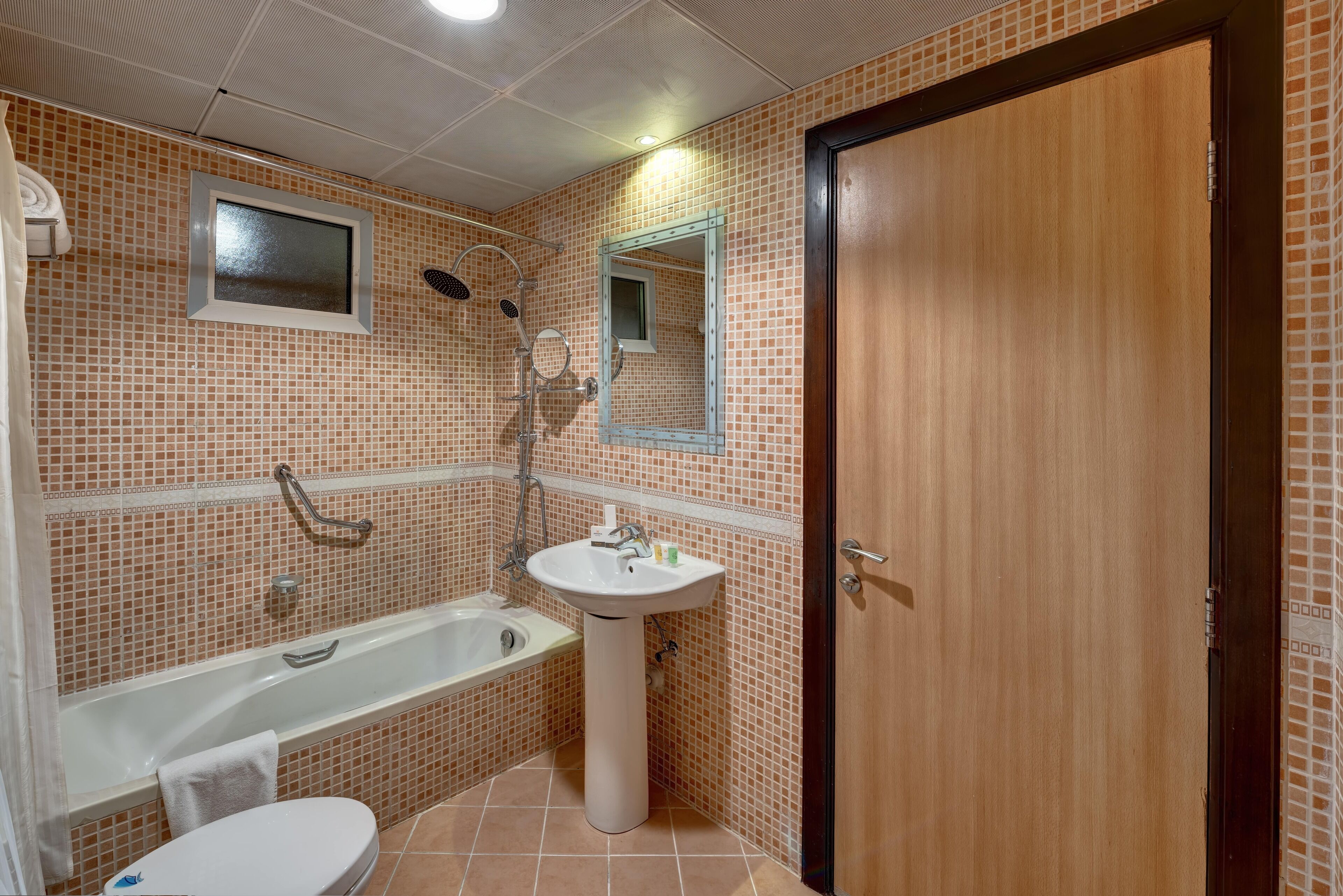 A bathroom with a bathtub, sink, and toilet.