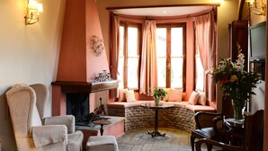 A cozy room with a fireplace, comfortable seating, and a television. - Hotel Ganimede (Delphi)
