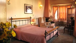 A bedroom with a bed, a chair, a table, and a window with curtains. - Hotel Ganimede (Delphi)