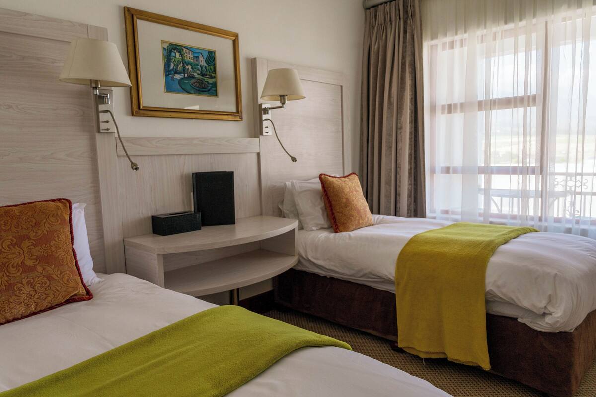 Een hotelkamer met twee bedden, een bureau en een televisie.