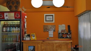 A reception area with a Coca-Cola refrigerator, a Hertz sign, and a bulletin board. - Neuquen Hostel Portal de Sueños (Neuquen)