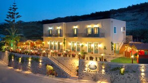 A two-story building with a stone facade, multiple balconies, and outdoor seating areas. - Kaliviani Traditional Hotel (Kissamos)