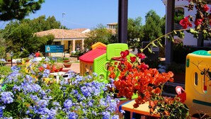 A hotel with colorful outdoor furniture and a sign indicating a restaurant. - Sa Fiorida Apartments (Valledoria)