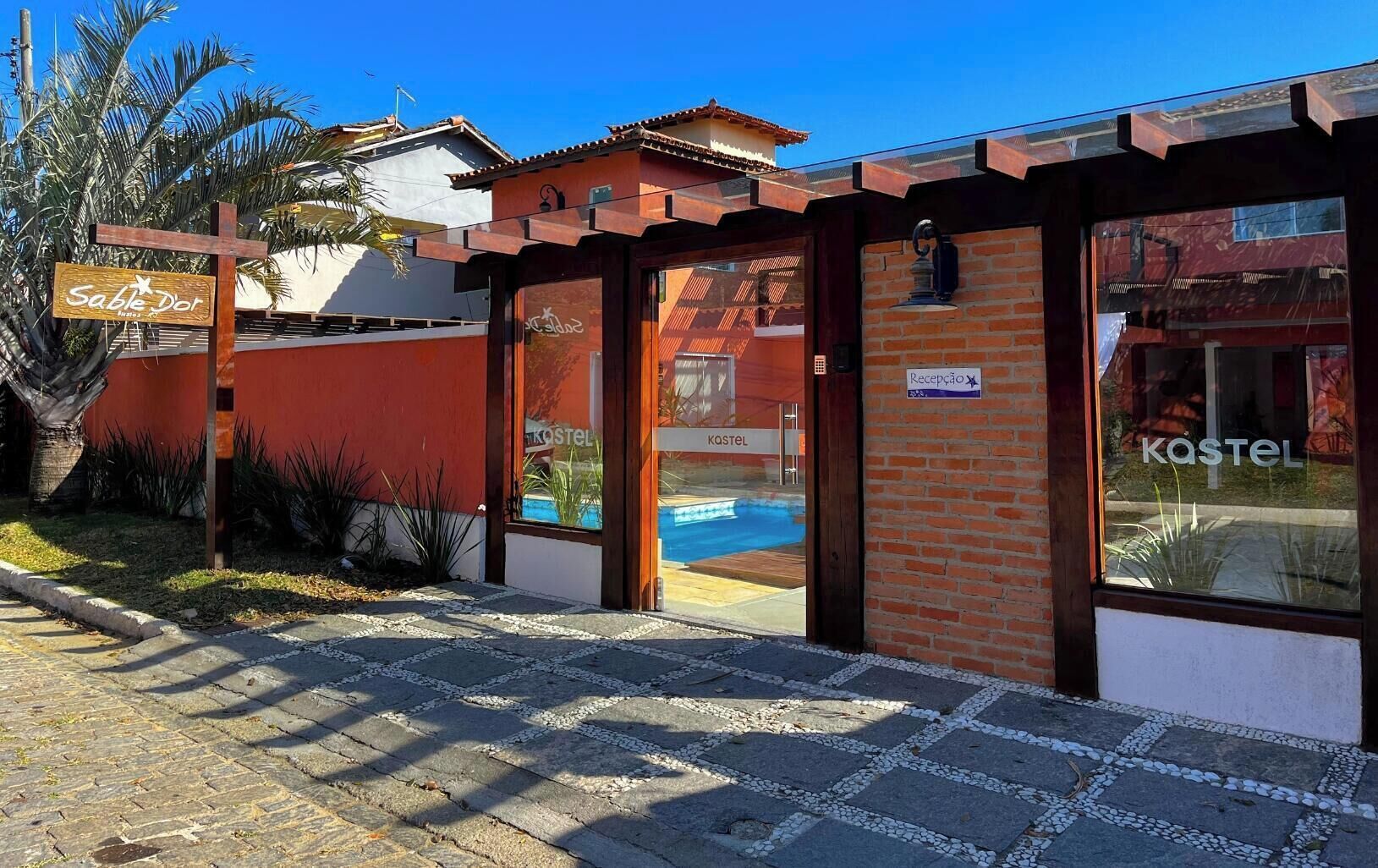 Ein Hostel mit Rezeption, einem Schild und einem Pool, der durch die Glastüren sichtbar ist.