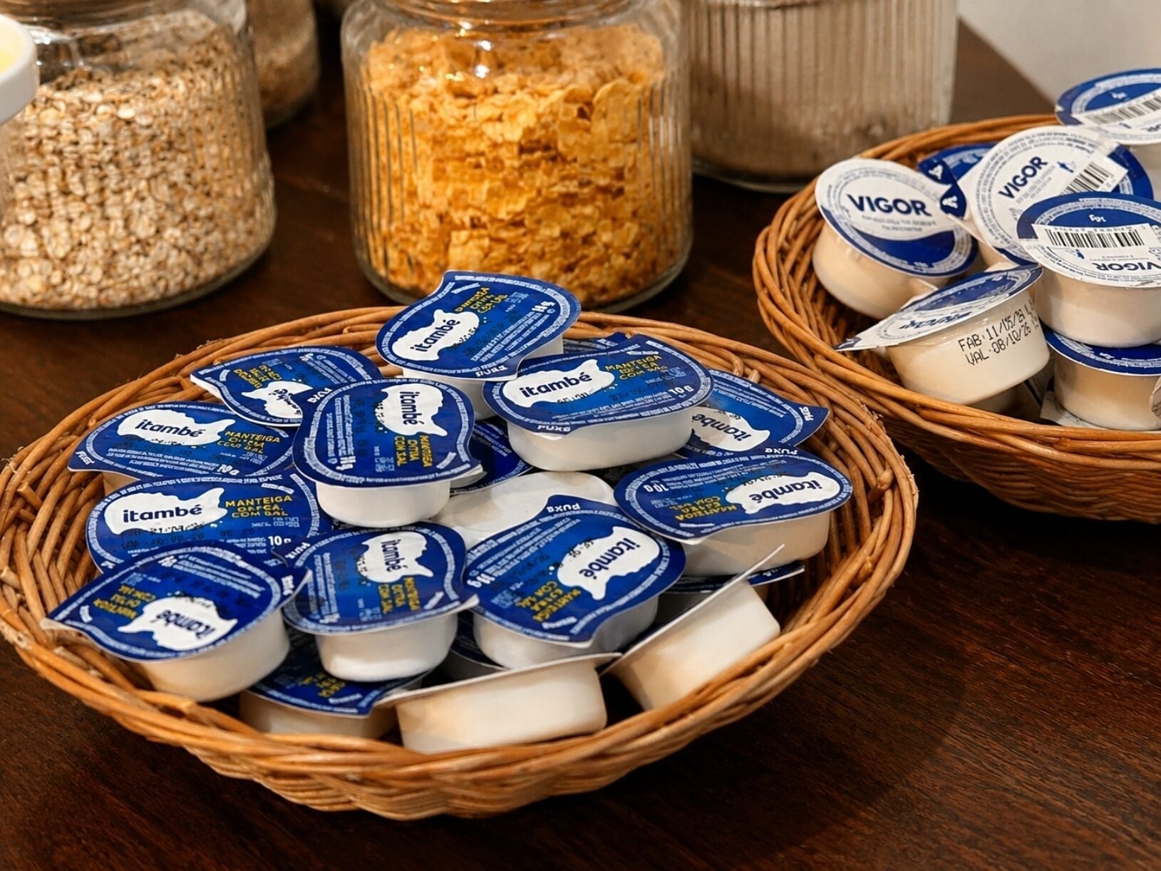 Un tavolo con cesti che contengono vasetti di yogurt e un barattolo di granola.