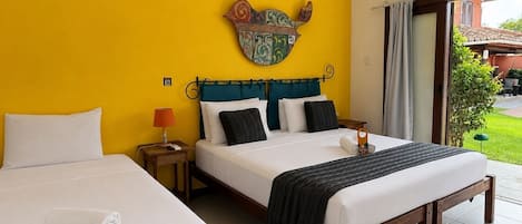 Habitación de hotel con dos camas, un adorno en la pared y vistas al exterior.