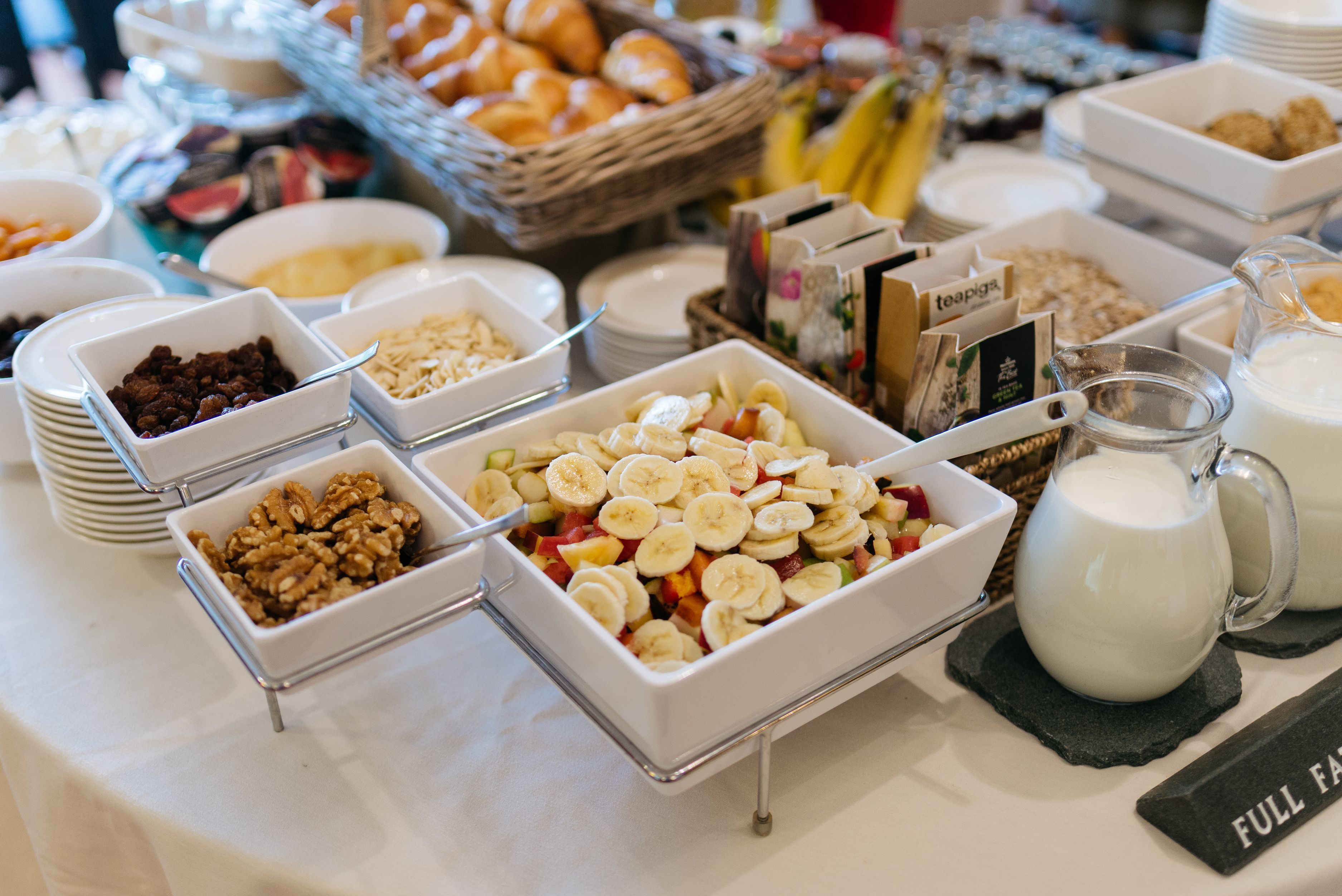 A buffet with various food items including fruits, nuts, and dairy products.