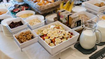 A buffet with various food items including fruits, nuts, and dairy products.