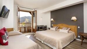 A hotel room with two beds, a desk, and a view of the mountains. - Hôtel Etchémaïté (Larrau)