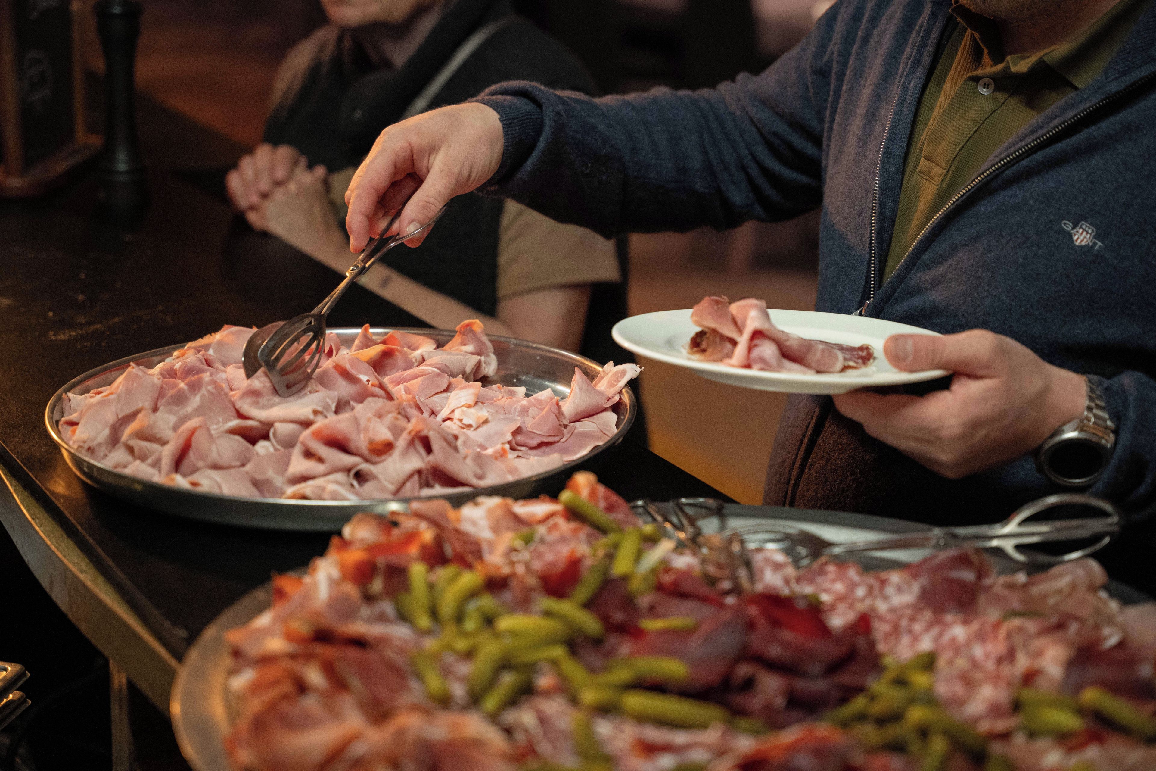 Een buffet met diverse gerechten, waaronder vleesschotels en groenten.