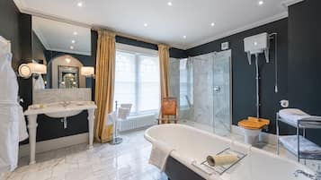 Une salle de bain moderne avec une baignoire sur pieds, un lavabo séparé et une douche à parois de verre.