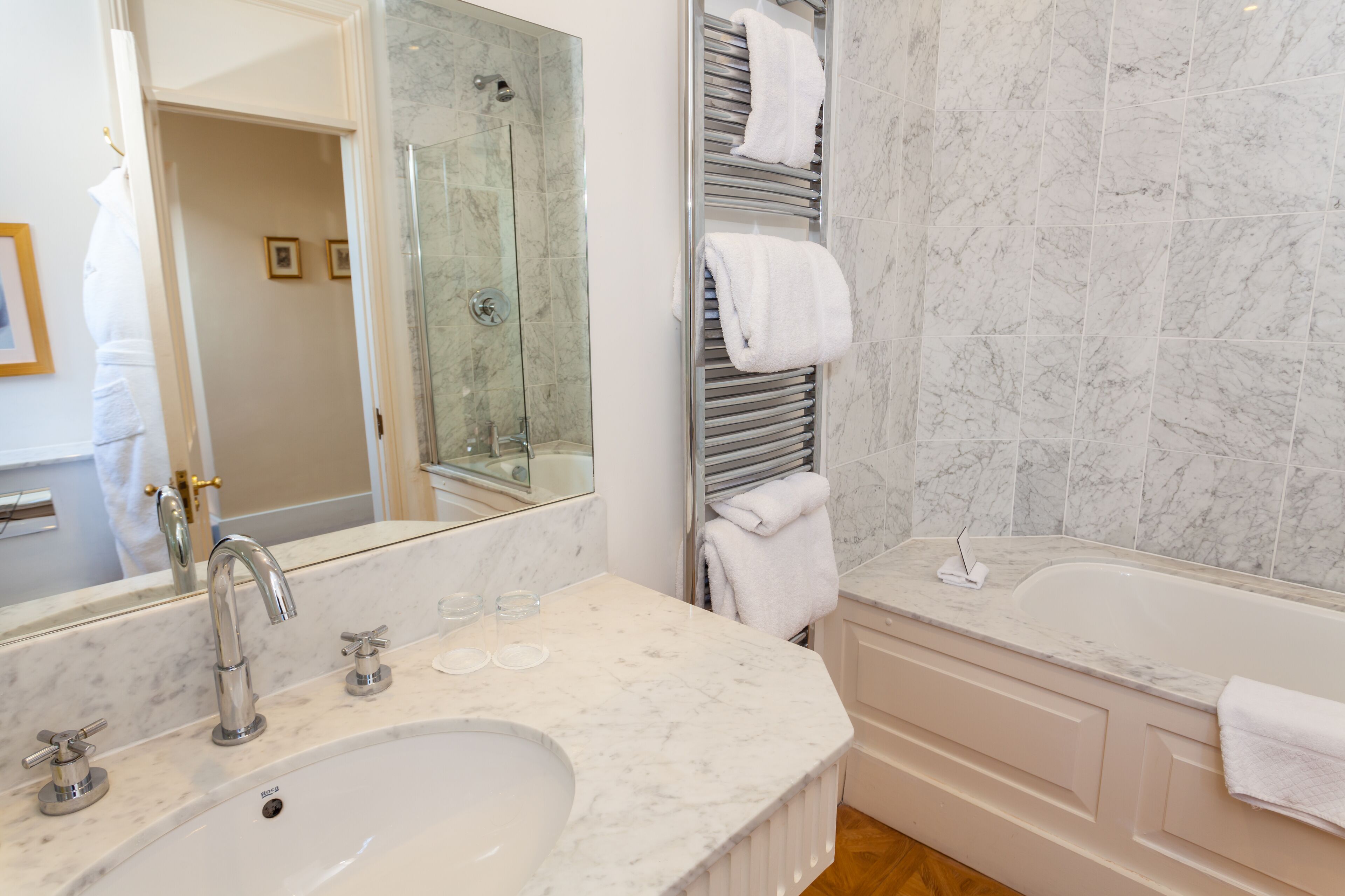 Un baño moderno con un lavamanos grande, una bañera y una ducha con mampara de vidrio.