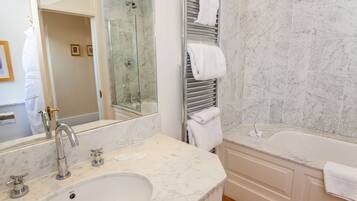 Un baño moderno con un lavamanos grande, una bañera y una ducha con mampara de vidrio.