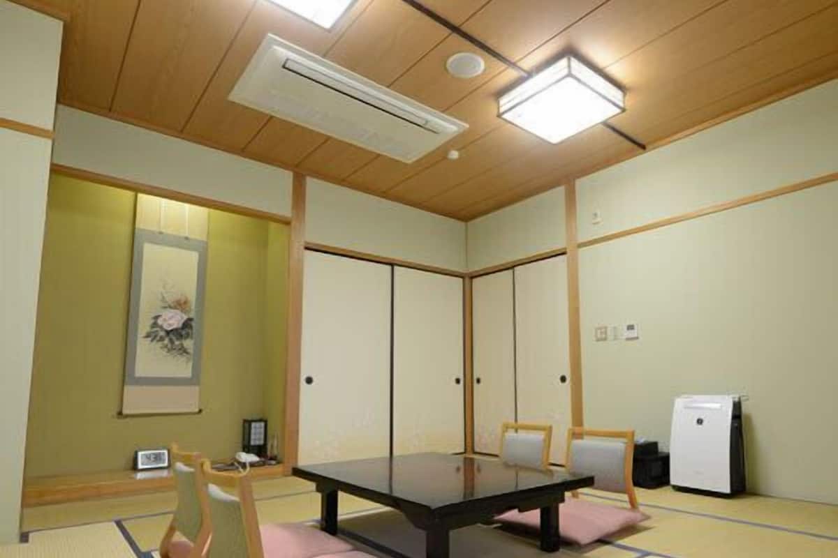 A traditional Japanese-style room with tatami flooring, a low table, and shoji screens.