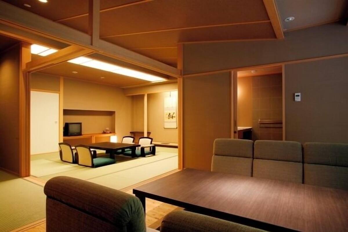Une pièce de style japonais traditionnel, avec un sol recouvert de tatamis, une table basse et des sièges.