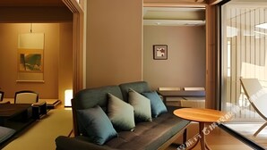 A modern living room with a sofa, a coffee table, and a dining area.