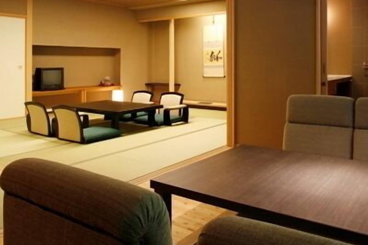 Une pièce avec une table en bois, des chaises, un téléviseur et un tableau encadré au mur.
