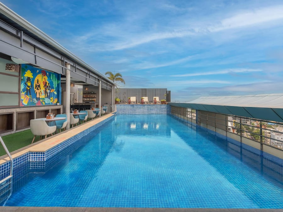 Una piscina al aire libre, sillones reclinables de piscina