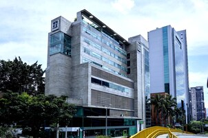 Un moderno edificio de hotel con un llamativo logotipo 'bh', amplias ventanas y un diseño arquitectónico distintivo.