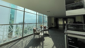 A modern office space with large windows, a conference table, and a view of the cityscape. - Hotel BH El Poblado (Medellín)