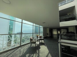 Un espacio de oficina moderno con ventanas amplias, una mesa de conferencias y vistas a la ciudad.