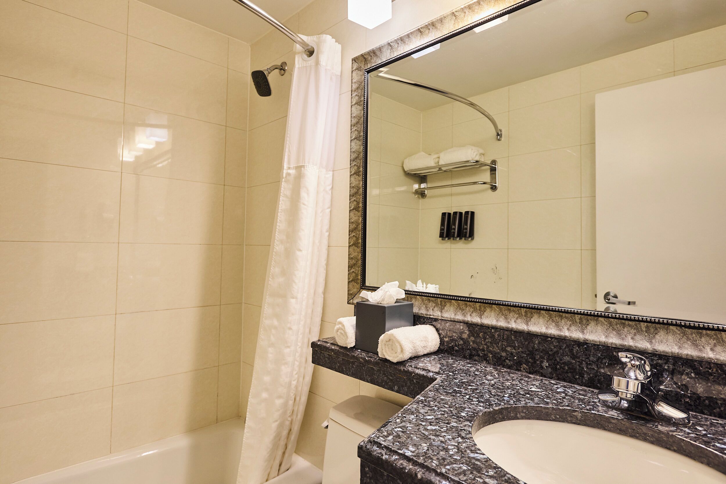Un baño con bañera, lavabo, espejo y cortina de ducha.