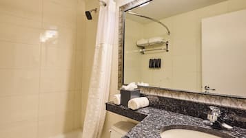 Un baño con bañera, lavabo, espejo y cortina de ducha.