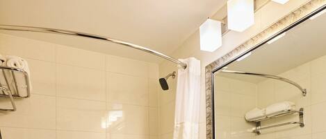 A modern bathroom with a bathtub, toilet, and a large mirror.