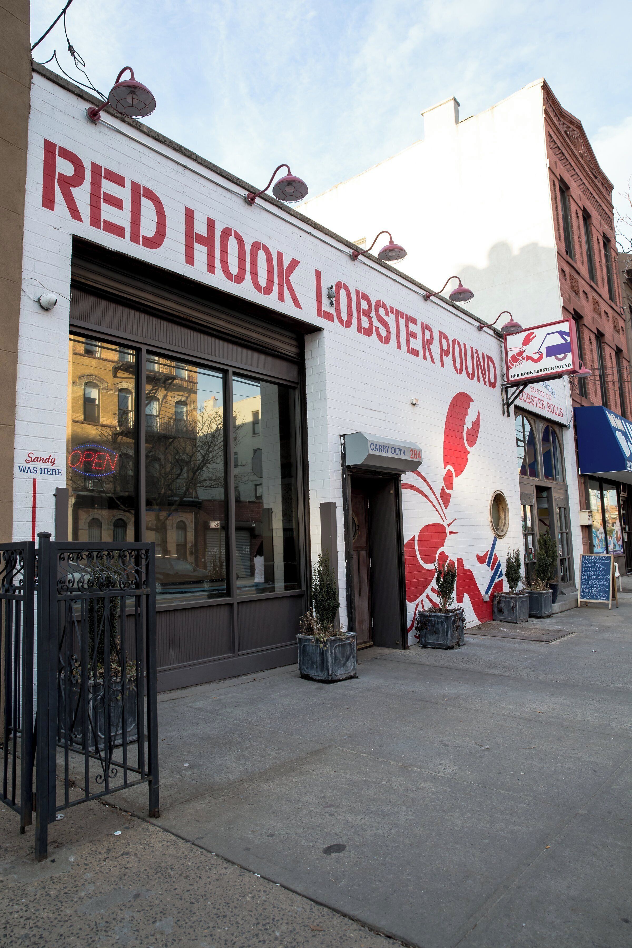 Une devanture de magasin avec une enseigne représentant un vivier à homards, une enseigne indiquant « Fermé » et une autre indiquant « Vente à emporter ».