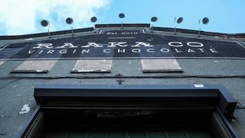 A building with a sign that reads "RAAKA CO. VIRGIN CHOCOLATE" and "Est. 2010".