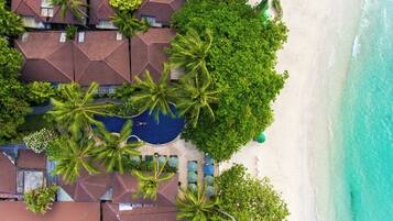 A resort with multiple buildings, a swimming pool, and a beach.