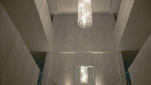 A modern interior with a central light fixture, a staircase, and a geometric wall design. - The Aknac Hotel (Accra)