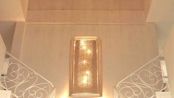 A staircase with a modern design, featuring a central light fixture and decorative railings.