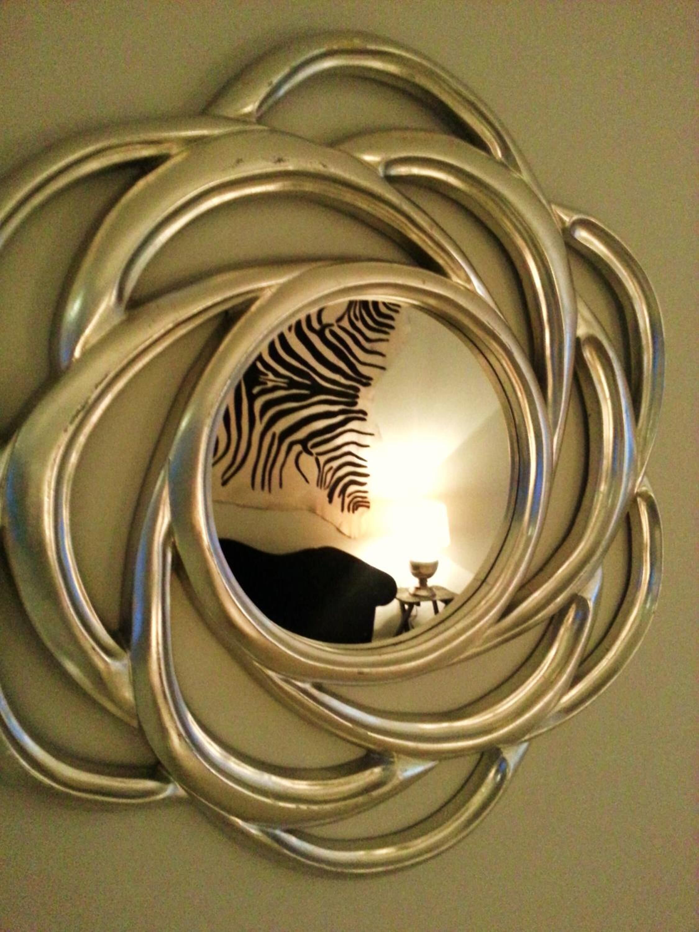 A circular mirror with a zebra-striped pattern.