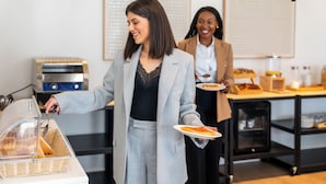 Un buffet avec une personne qui sert les plats, un présentoir pour les aliments et un comptoir où sont exposés divers articles.