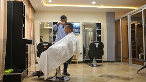 A modern barbershop with a clean, tiled floor and a large mirror. - Soramba Hotel (Addis Ababa)