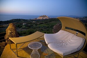 Una piscina al aire libre, sombrillas, sillones reclinables de piscina